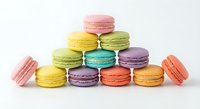 Colorful French macarons in rainbow hues stacked and arranged on white background. Sweet pastry dessert collection for bakery menu and culinary design.