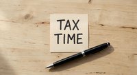 Tax time reminder note on wooden desk with black pen, symbolizing financial planning, tax season preparation, and accounting deadlines.