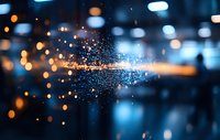 Magical glowing particles with blue and orange bokeh lights creating atmospheric depth effect against dark background, perfect for festive designs and backgrounds.