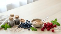 Natural organic skincare ingredients with fresh berries, herbs and clay mask on wooden table for homemade beauty treatments and wellness routines.