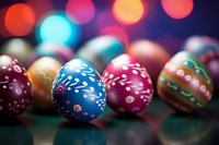 Colorful decorated Easter eggs with traditional folk patterns on dark background with festive bokeh lights creating magical holiday atmosphere.