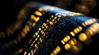 Digital binary code glowing on dark background with selective focus, golden light effect creates futuristic technology pattern for cybersecurity concepts.