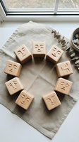Wooden emotion blocks arranged in circle showing different facial expressions for mindfulness therapy and emotional learning activities on natural linen fabric.