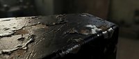 Close-up of weathered charcoal or burnt wood surface with textured, cracked patterns and ash residue, suitable for backgrounds, design elements, or industrial themes.