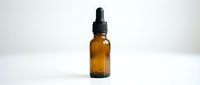 Amber glass dropper bottle with black pipette cap on white background, suitable for essential oils, serums, tinctures, and cosmetic product packaging.