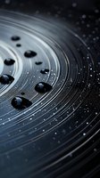 Water drops on dark circular grooved surface with dramatic lighting and bokeh effects create abstract macro photography composition for backgrounds.