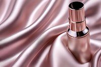 Luxury cosmetic bottle mockup on pink silk satin background with elegant folds and shadows, premium skincare product presentation for beauty brands.