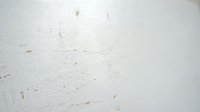 Weathered white painted surface with scratches, marks and wear patterns, suitable for backgrounds, textures and design overlays.