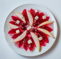 Fresh pear and watermelon radish arranged in floral pattern on white plate, garnished with feta cheese cubes and pink peppercorns for elegant appetizer.