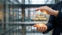 Businessman hands protecting glowing trust network sphere in modern office environment representing security and professional relationships.