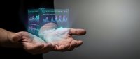 Businessman holding holographic financial data display with stock charts and analytics graphs in cupped hands against gray background for business technology concepts.
