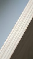 Close-up of plywood edge showing natural wood grain layers and texture for construction and carpentry projects.