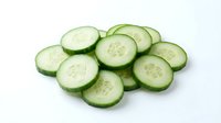 Fresh cucumber slices arranged on white background, perfect for healthy eating concepts, cooking ingredients, and culinary designs.