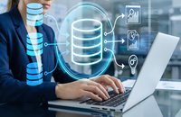 Professional businesswoman working on laptop with digital database management system and analytics icons in modern office environment.