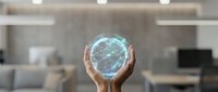 Hands holding glowing digital globe with network connections in modern office environment representing global business technology and connectivity solutions.
