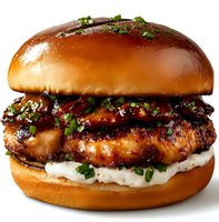Glazed chicken burger with teriyaki sauce and mayo on brioche bun garnished with fresh green onions, close up view on white background.