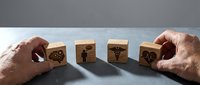 Hands arranging wooden cubes with healthcare medical icons symbols for hospital management and patient care planning concepts.