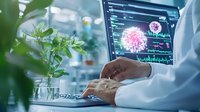 Medical researcher analyzing virus data on computer screen with green plant in foreground, creating modern laboratory atmosphere for healthcare and scientific research.