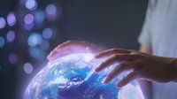 Hands gently touching glowing Earth globe with blue and purple light effects, symbolizing global connection, environmental care, and sustainable technology for business and innovation concepts.