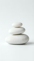 Stacked white smooth stones balanced on neutral background, symbolizing zen, wellness, meditation, spa therapy, and mindfulness practices for relaxation.