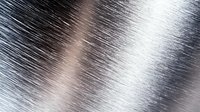Brushed metal surface with diagonal scratched texture pattern in silver and copper tones creating industrial abstract background for design projects.