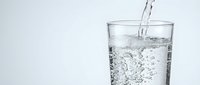 Clear water being poured into transparent glass with bubbles and splash, refreshing drink concept for health and hydration lifestyle on white background.