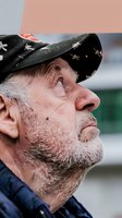Senior man with gray beard wearing black baseball cap with star pattern, side profile portrait for lifestyle and age-related content.