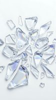 Scattered transparent glass shards and fragments with iridescent reflections arranged on white background, isolated for design, packaging, and creative projects.