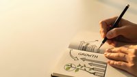 Business growth strategy planning with hand drawing financial charts and graphs in notebook for startup development and investment analysis.