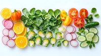 Fresh colorful vegetables and fruits neatly arranged in rows on white background including orange slices, radish, tomatoes, cucumber, brussels sprouts and green salad leaves.