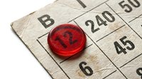 Red bingo chip placed on numbered card with B column and number 12, used for gaming, entertainment, and leisure activities.