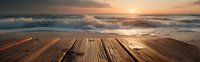 Wooden pier or deck overlooking dramatic ocean waves at sunset, creating serene coastal atmosphere with golden light reflecting on water surface.
