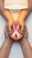 Hands holding a pink ribbon with hope inscription, breast cancer awareness symbol, support and solidarity concept.
