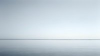 Minimalist seascape with calm waters meeting overcast sky at horizon, conveying tranquility and solitude for meditation, wellness, and contemplative design projects.