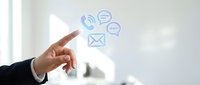 Business professional hand touching digital communication icons including phone, chat, and email symbols floating in modern office environment for customer service.