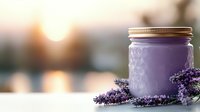 Purple glass jar with fresh lavender sprigs against blurred sunset background creates calming spa and wellness atmosphere for aromatherapy and natural cosmetics.
