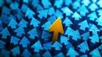 Standing out yellow arrow among blue arrows pointing upward, leadership concept showing uniqueness and different direction in business strategy.