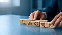 Healthcare business growth strategy with wooden blocks displaying medical and financial icons, representing insurance, wellness, and revenue expansion.