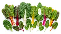 Fresh colorful rainbow chard leaves with vibrant stems arranged on white background, perfect for healthy cooking and nutrition concepts.