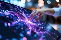 Female hand touching interactive digital display with glowing purple and blue particle effects, creating magical light trails and bokeh background for technology concept.