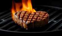 Heart-shaped juicy grilled beef steak with grill marks and flames on black iron grate, dramatic dark food photography with selective focus.
