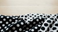 Crumpled black and white polka dot fabric with contrasting patterns, suitable for textile design, fashion backgrounds, and print material projects.