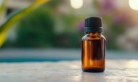 Amber glass essential oil bottle on blurred natural background with bokeh lights. Small aromatherapy container for wellness and alternative medicine.