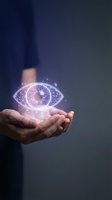 Male hand holding glowing digital eye with purple light effects against dark background. Represents vision, technology, innovation, artificial intelligence, and future concepts for business and digital design use.