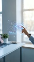 Person with medium skin tone wearing light blue shirt and smartwatch touching holographic brain display with data analytics charts and graphs in modern office near window.