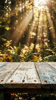 Weathered wooden table surface with blurred forest background featuring golden sunlight rays filtering through trees, ideal for product display and nature-themed designs.