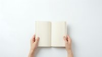 Female hands holding open blank notebook with empty pages on white background. Minimalist flat lay composition for mockup design projects.