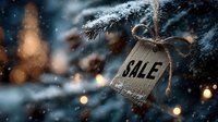 Wooden sale tag hanging on snowy pine branch with warm bokeh lights in background, creating festive winter holiday shopping atmosphere.