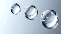 Floating water drops with air bubbles captured in macro photography against light gray background show surface tension and reflection effects.