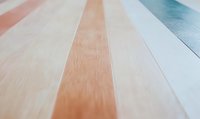 Diagonal lines of pastel colored wooden planks create modern minimalist pattern with soft pink, beige and blue tones, suitable for interior design backgrounds.